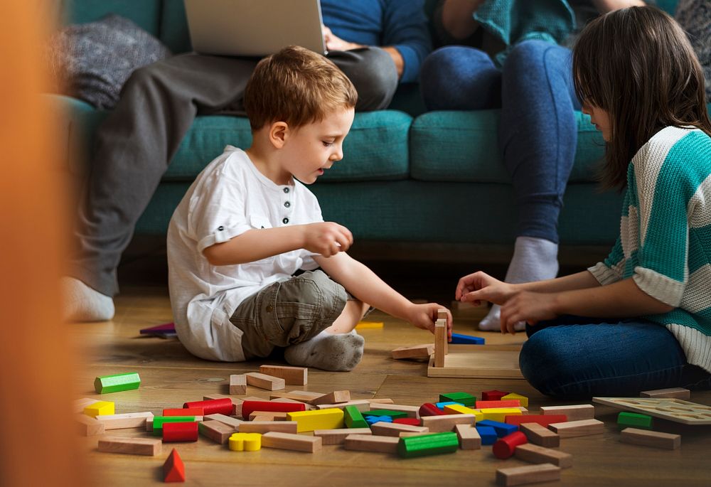 Kids playing wooden blocks on the floor