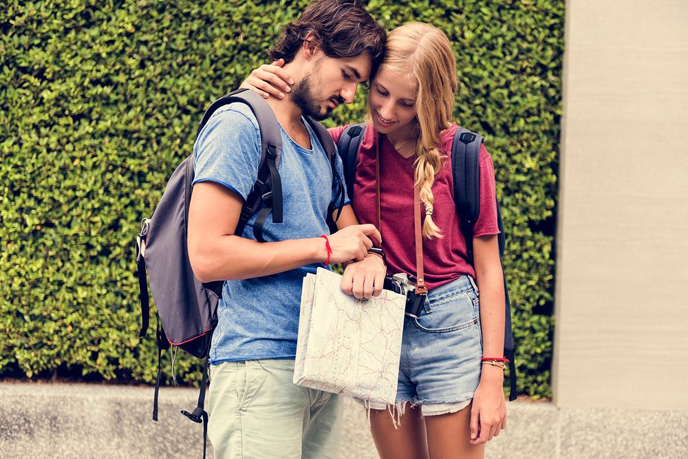 Couple traveling with map checking time
