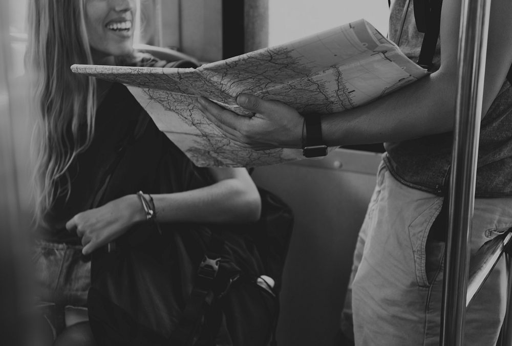 Man holding a map showing her girlfriend their next stop