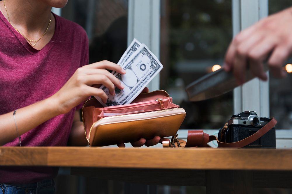 Woman paying cash for bill restaurant