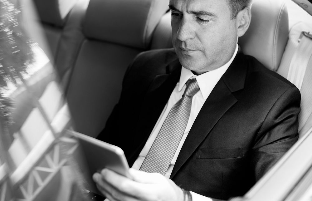 Businessman Using Tablet Working Car Inside