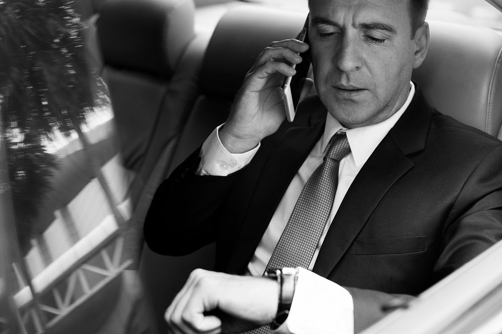 Businessman talking on a phone in a car