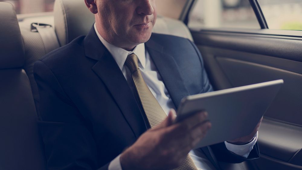 Businessman Using Tablet Working Car Inside