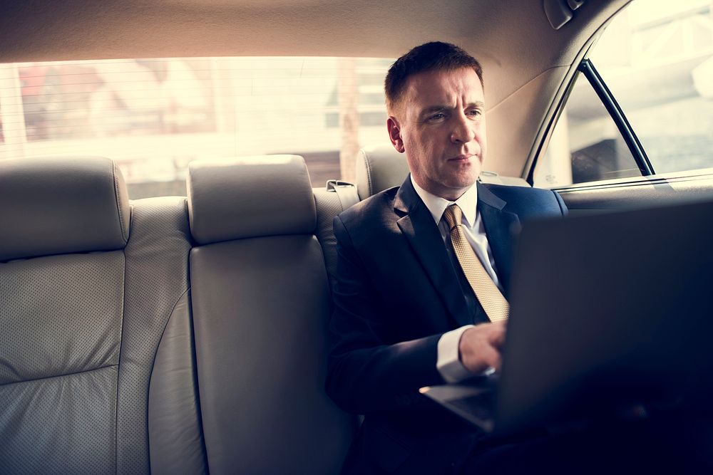 Businessman Using Laptop Car Inside