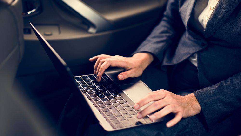 Business People Using Laptop Networking Car Inside