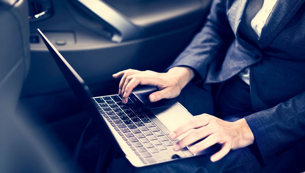 Business People Using Laptop Networking Car Inside