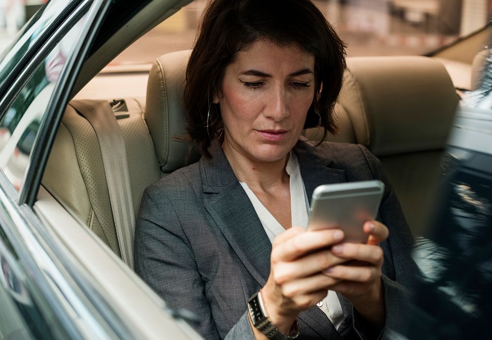 Businesswoman Using Smart Phone Car Inside