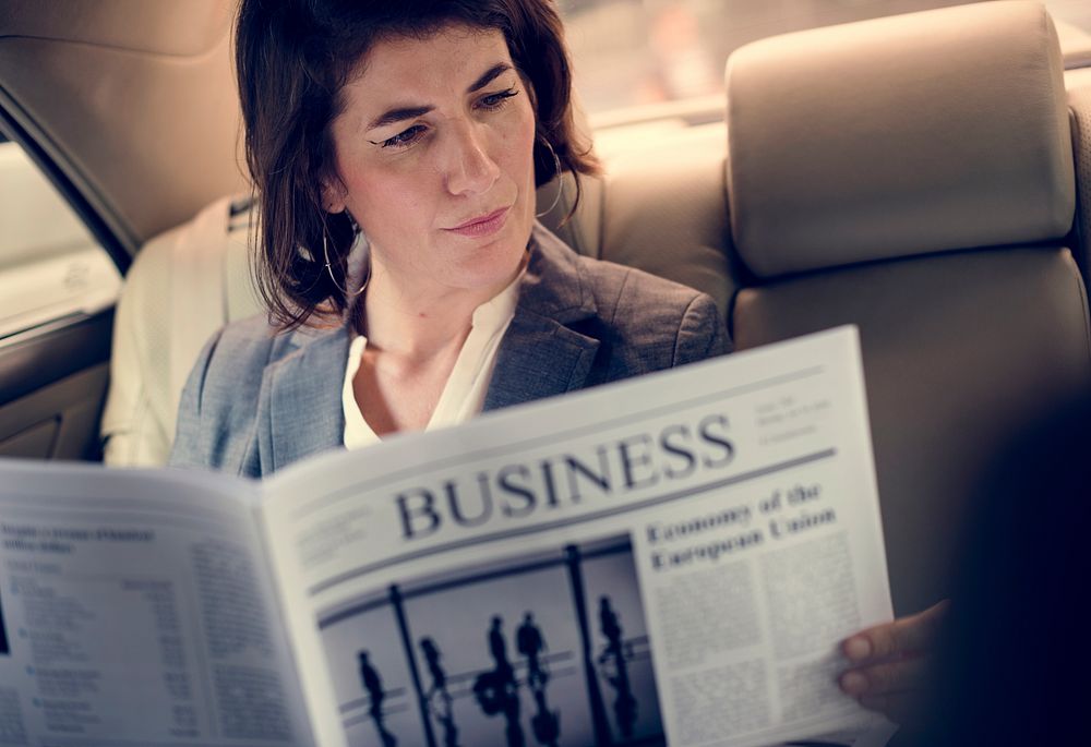 Businesswoman Reading Newspaper Car Inside
