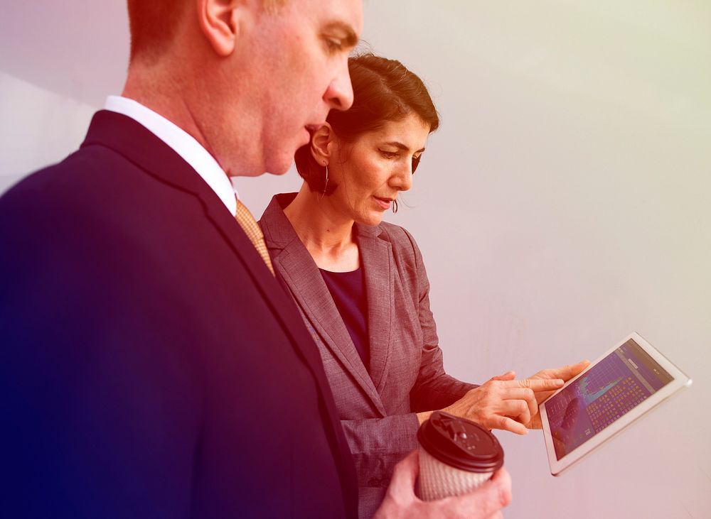 Business people analysing on digital tablet with partner
