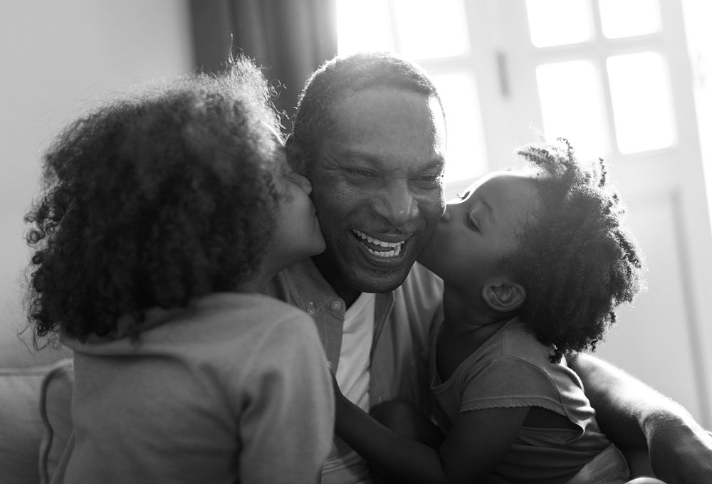 African descent family home, kids kissing their father