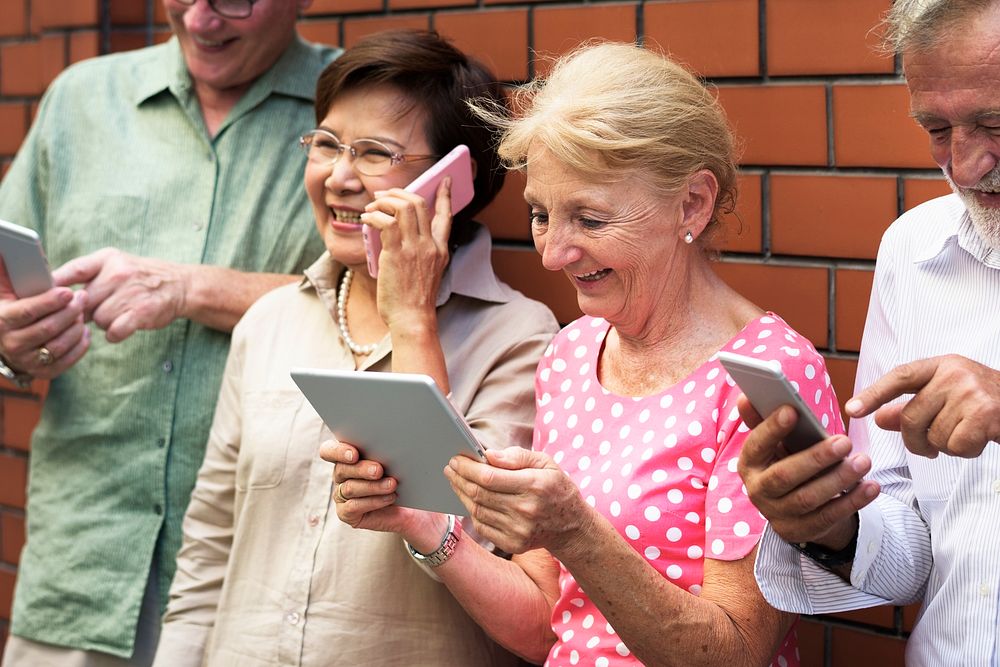 Group of diverse elderly using digital devices