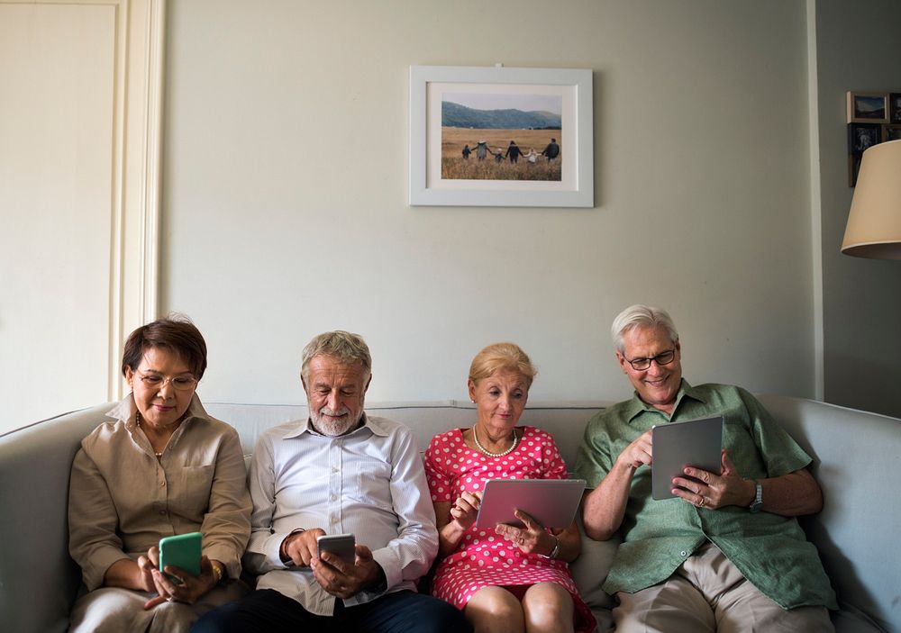 Senior adults using digital devices together