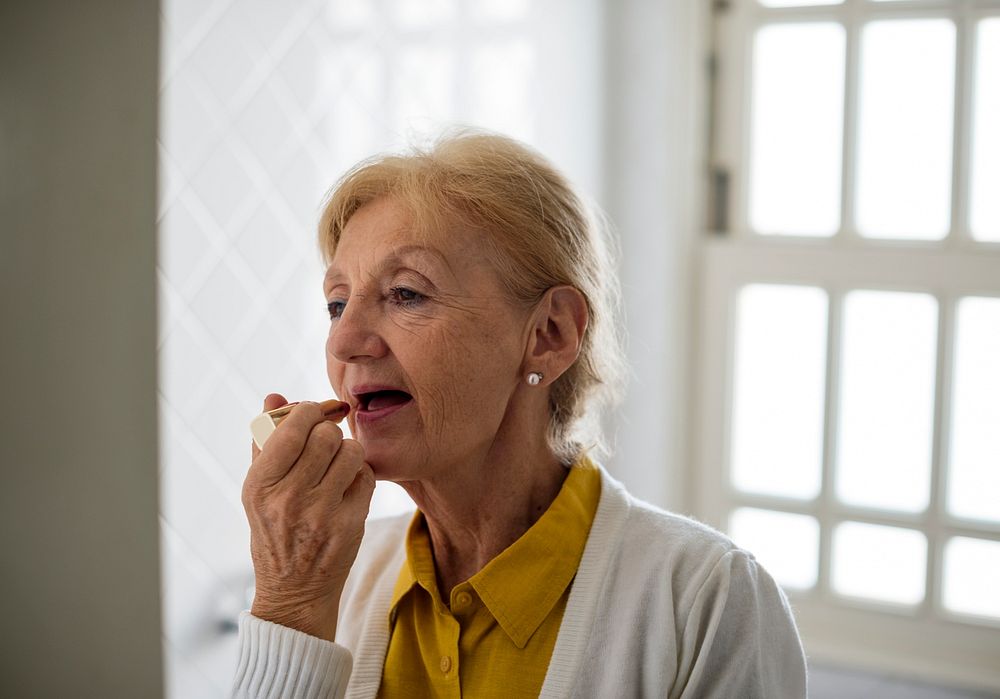 Senior woman dressing and appyling makeup in a morning routine