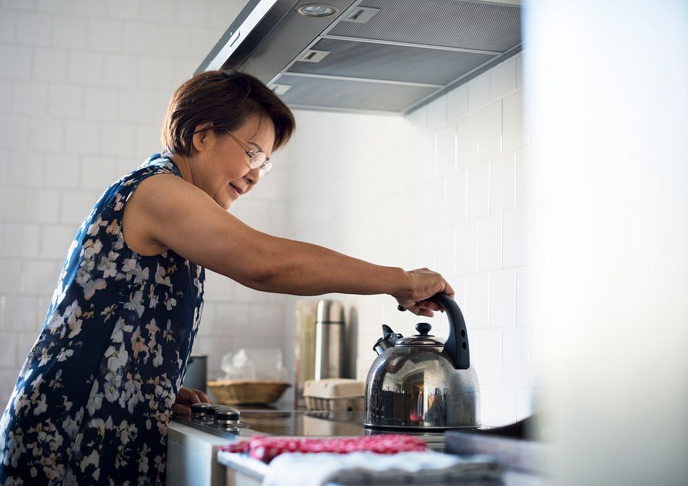 Senior woman cooking food in the kitchen