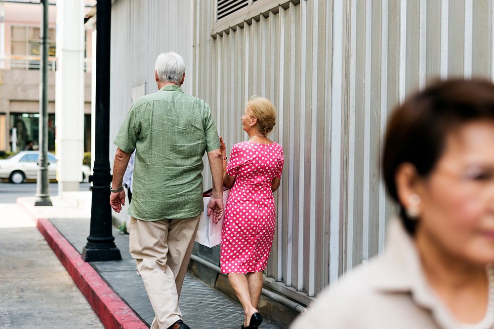 Senior couple with shopping bags walking on the street