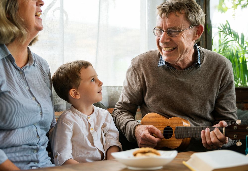 Grandparents with grandson having fun with ukelele