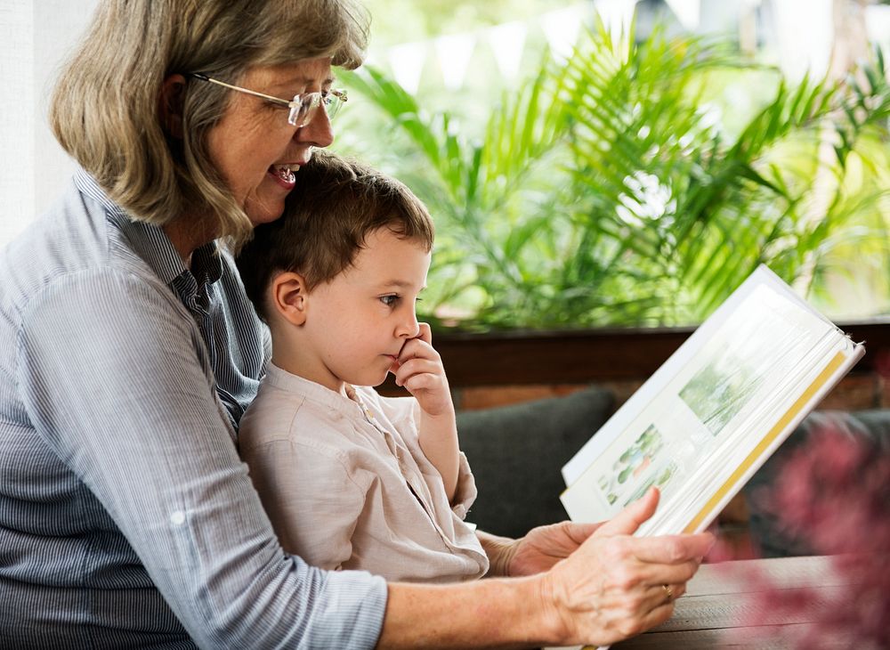 Grandmother and grandson reading a book together