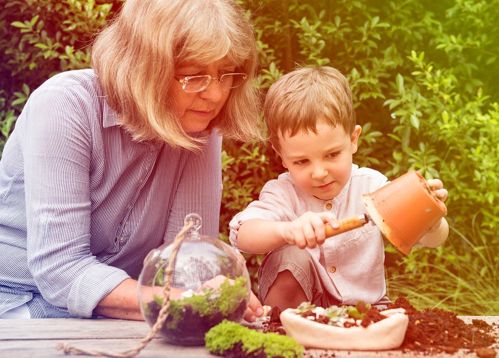 Grandmother and grandson planting and decorating the garden