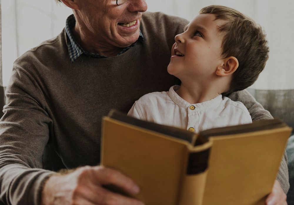 Grandfather and grandson reading a book together