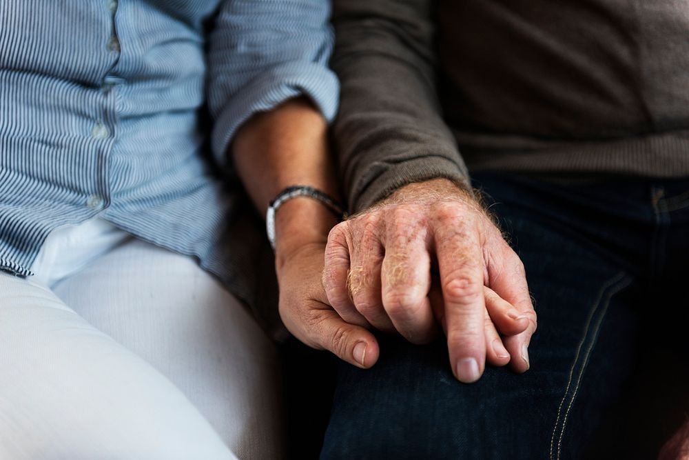 Hands of elderly couple holding each other