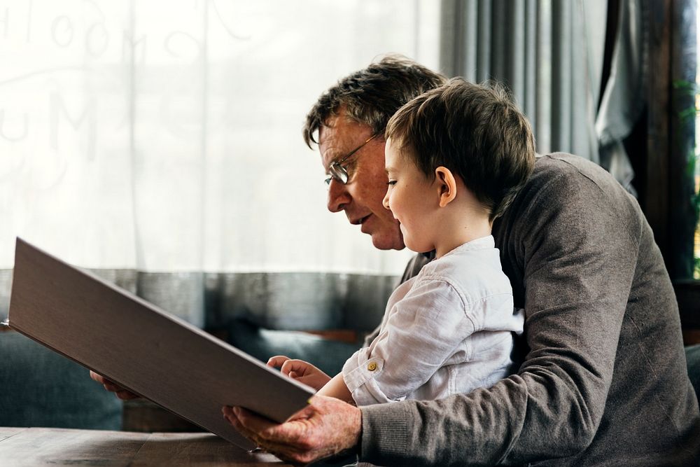 Grandfather and grandson reading a book together