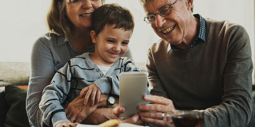 Grandparents and grandson using mobile phone