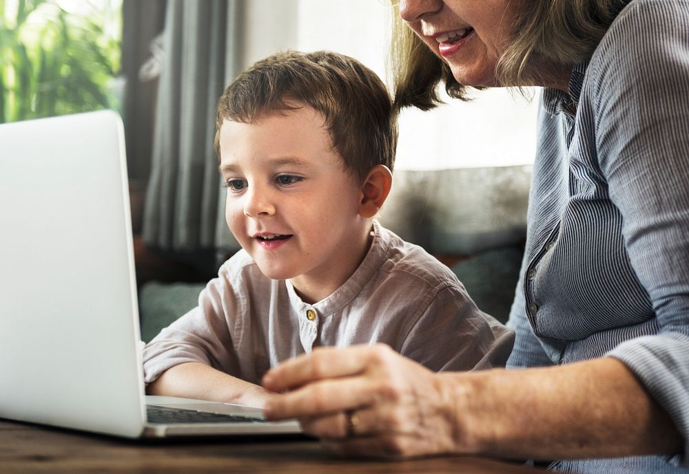 Grandmother and grandson using the laptop together