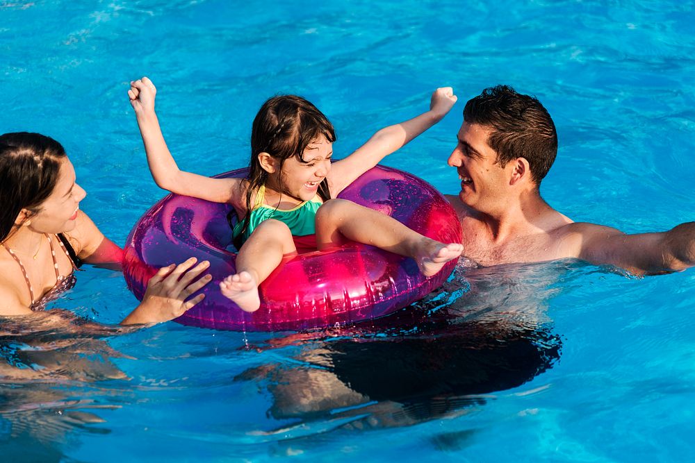 Mixed family enjoying summer pool time