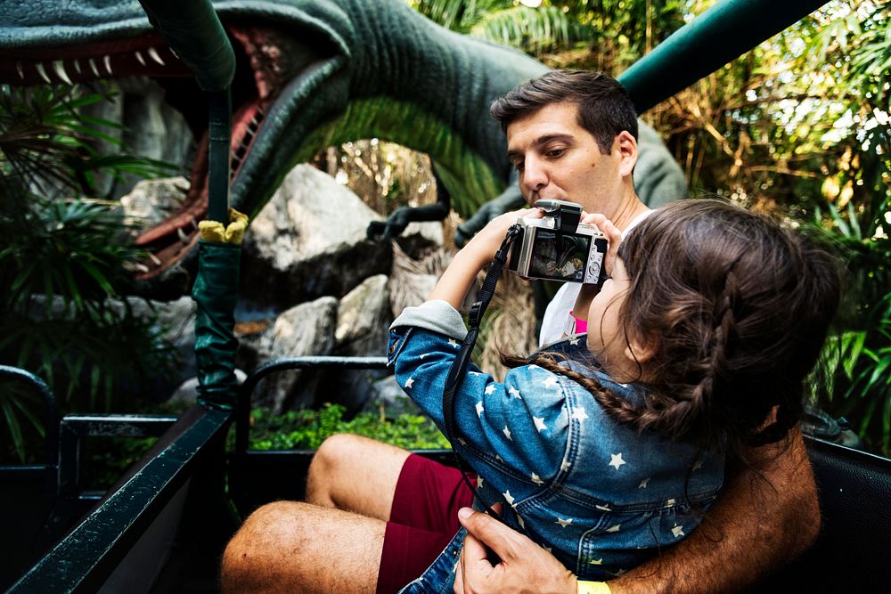 Dad carrying daughter while taking a photo