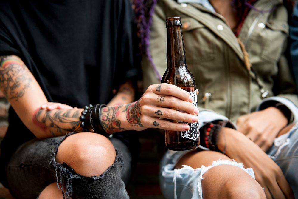 Tattooed woman holding a bottle of beer