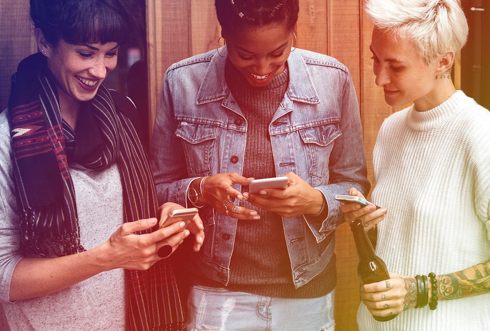 Group of girlfriends connected by mobile phone network