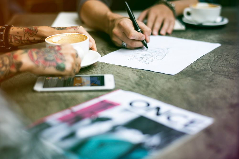 People drawing and sharing ideas at coffee shop