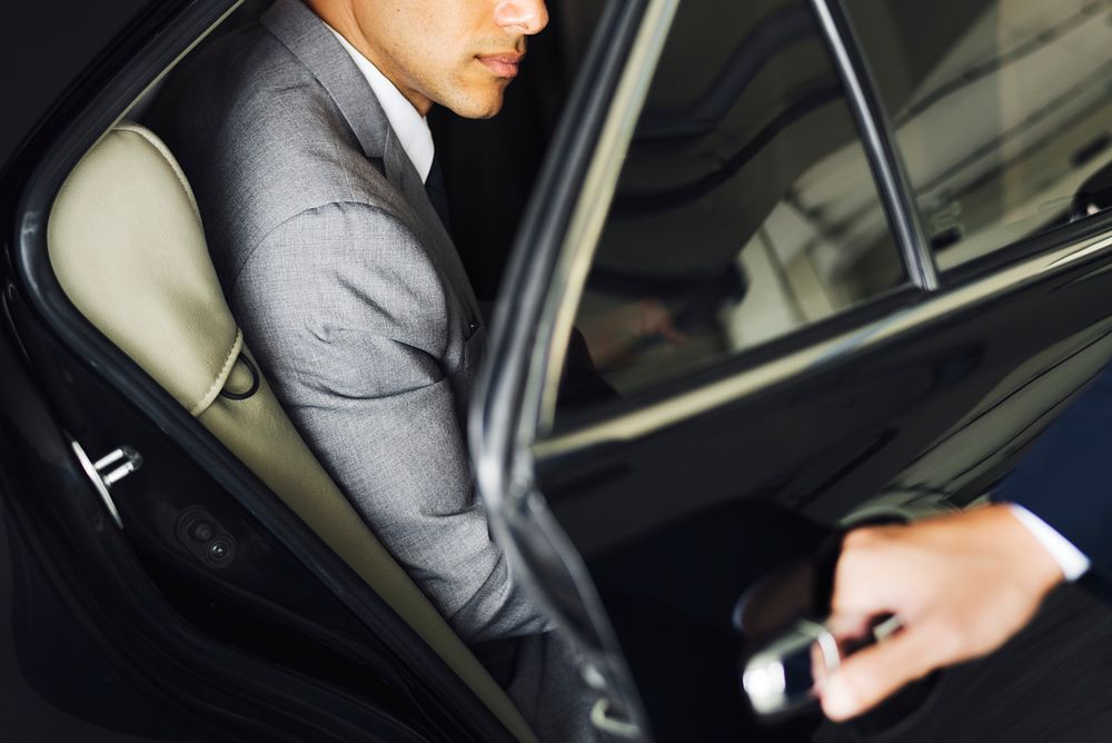 Driver opening door for businessman