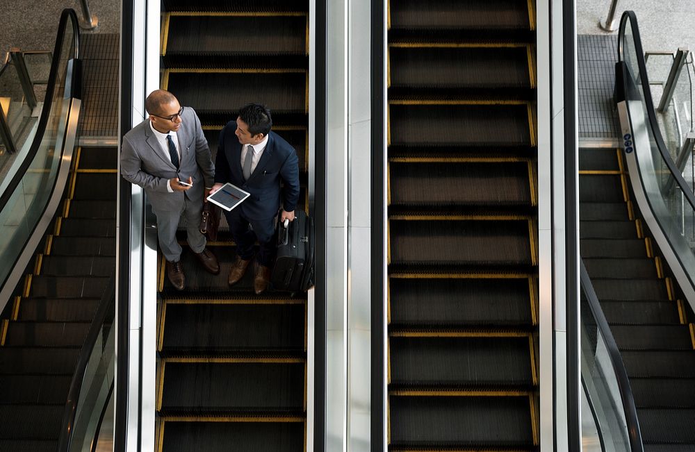Business Men Talk Tablet Escalator