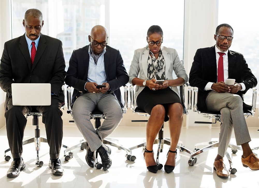 A Group of International Business People Are Sitting and Using Wireless Devices 