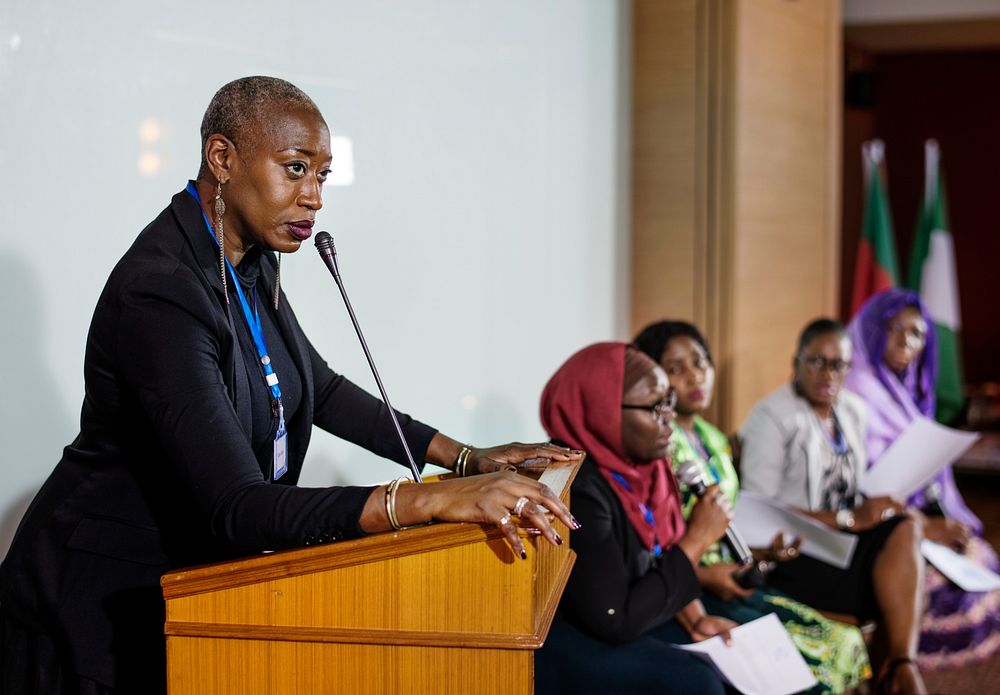 A Middle African Descent Woman Speaking into a Microphone