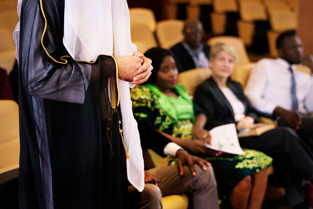 A Person Standing in a Room Filled with Many Business Delegates