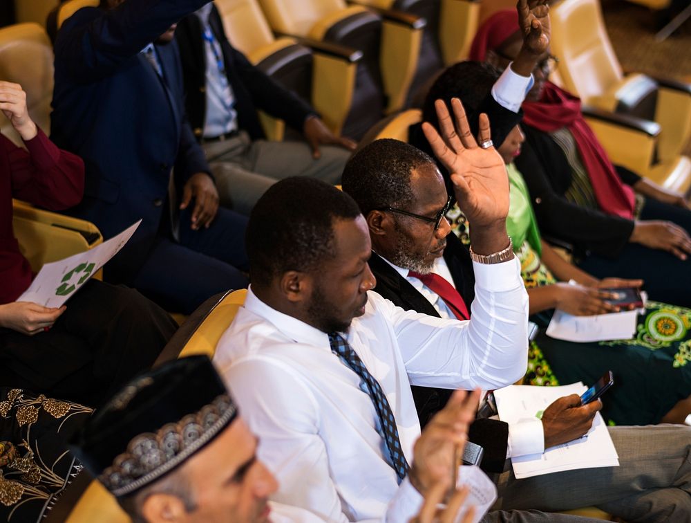 An African Descent Man is Raising His Hand in a Business Meeting