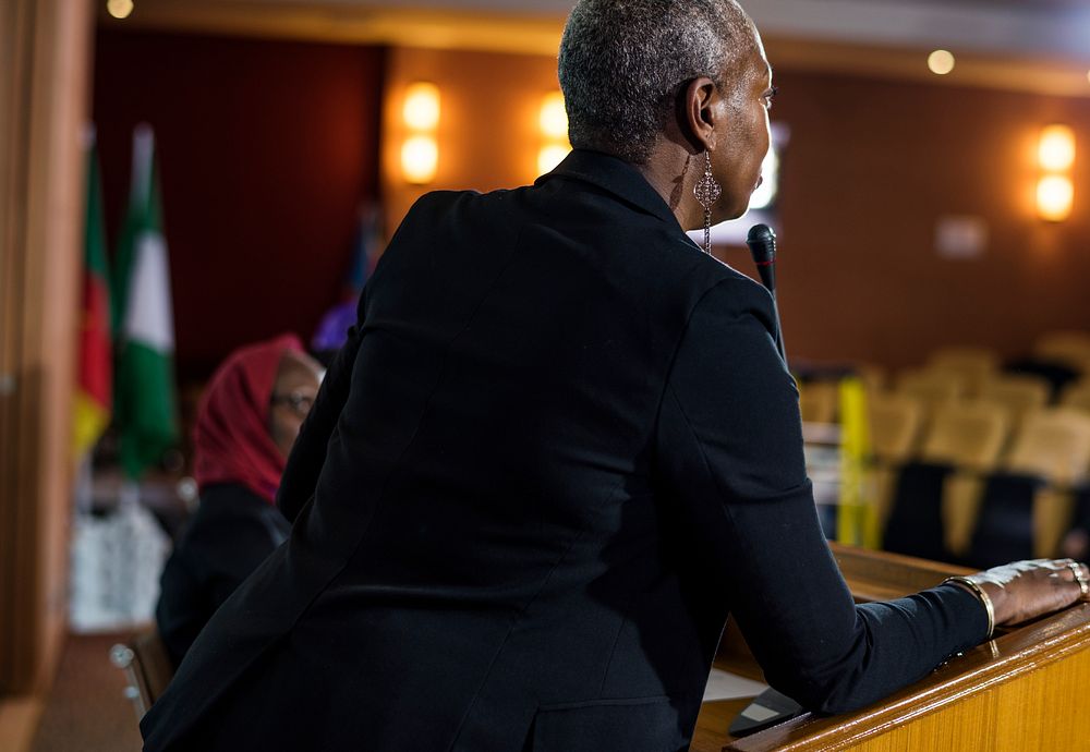 A Middle Age African Descent Woman Speaking into a Microphone