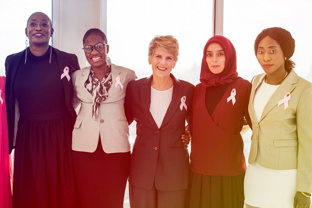 Diverse team together with pink ribbon
