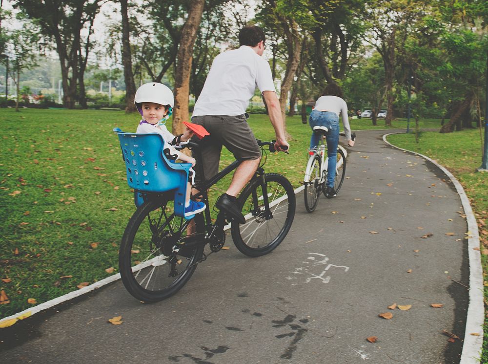 Family riding bicycles through the park