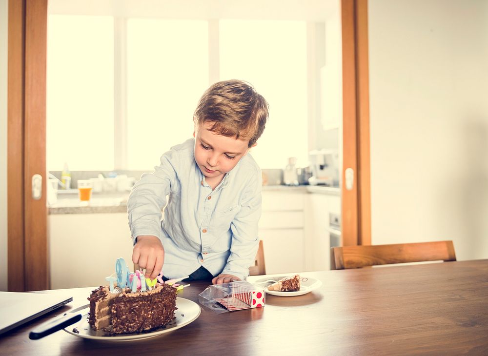Little boy take out the candle of his chocolate birthday cake