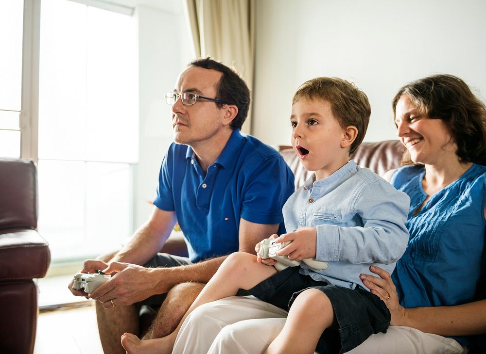 Family playing video games together on weekend holiday