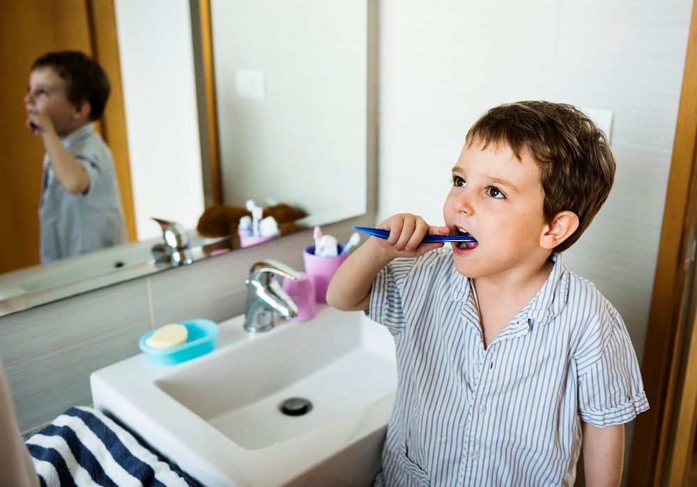 Little boy brushing his teeth on his own