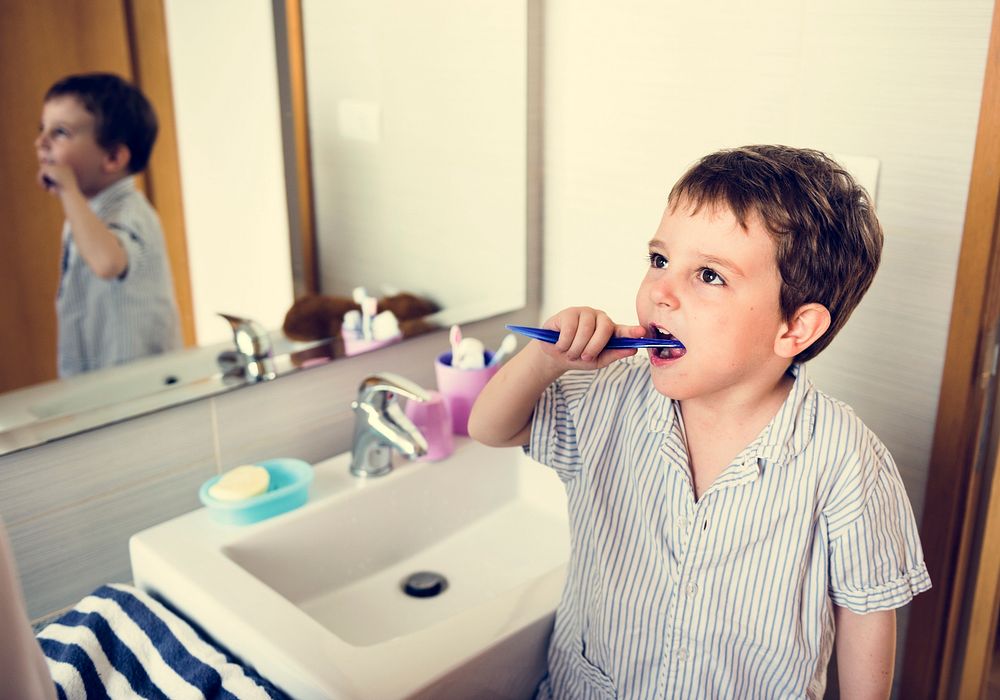 Little boy brush his teeth in restroom in the morning