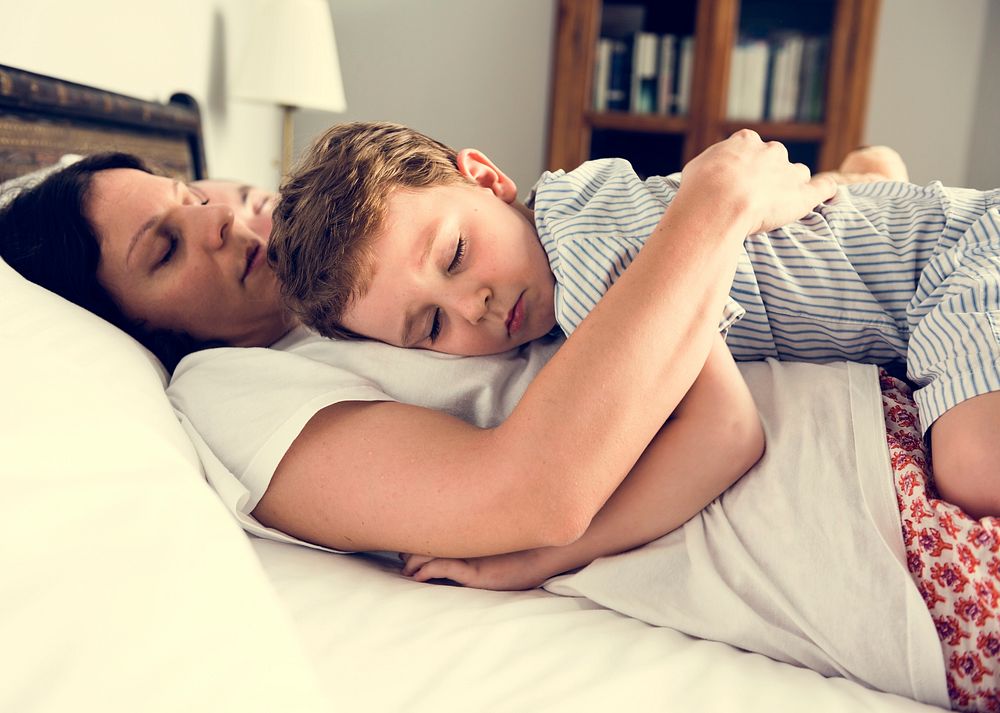 Family sleeping on the bed togetherness