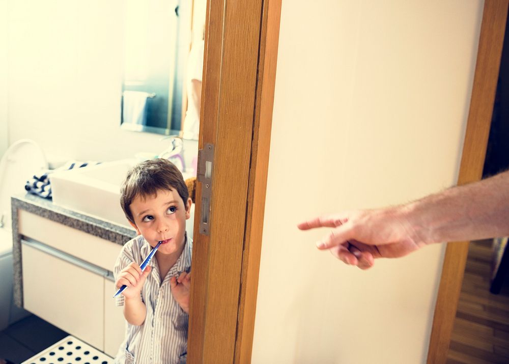 Hand of parents order the boy to brush his teeth