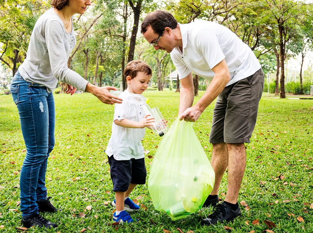 Family picking up trash in the park