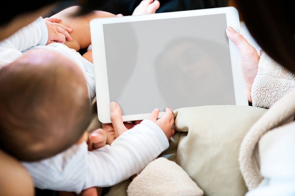 Parents using digital device with their baby
