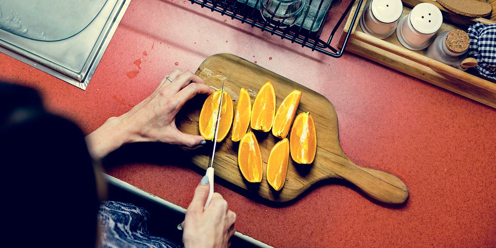 A sliced orange is on a wooden cutting board.